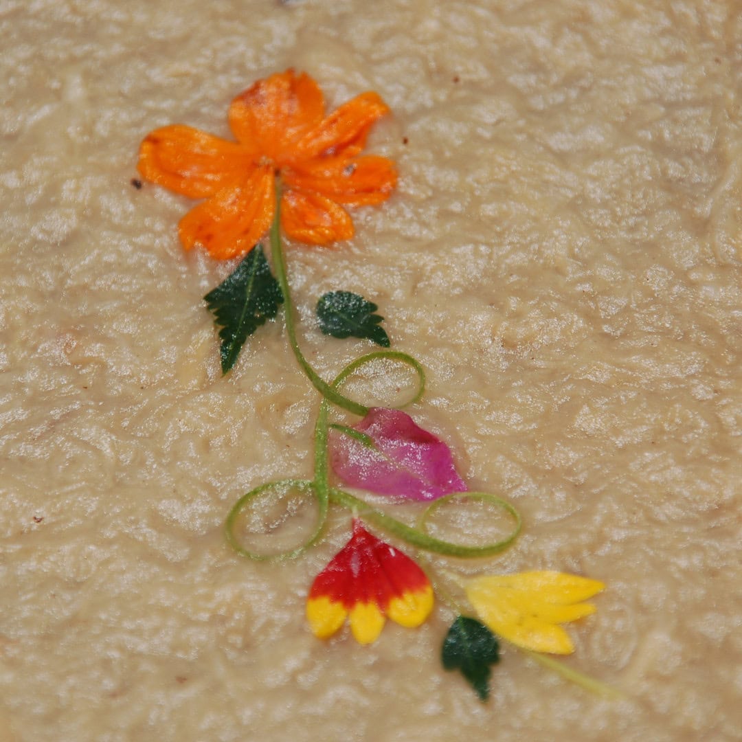 Bunte Blumenmuster-Dekoration auf strukturierter beiger Oberfläche, verleiht künstlerischen und natürlichen Charme.