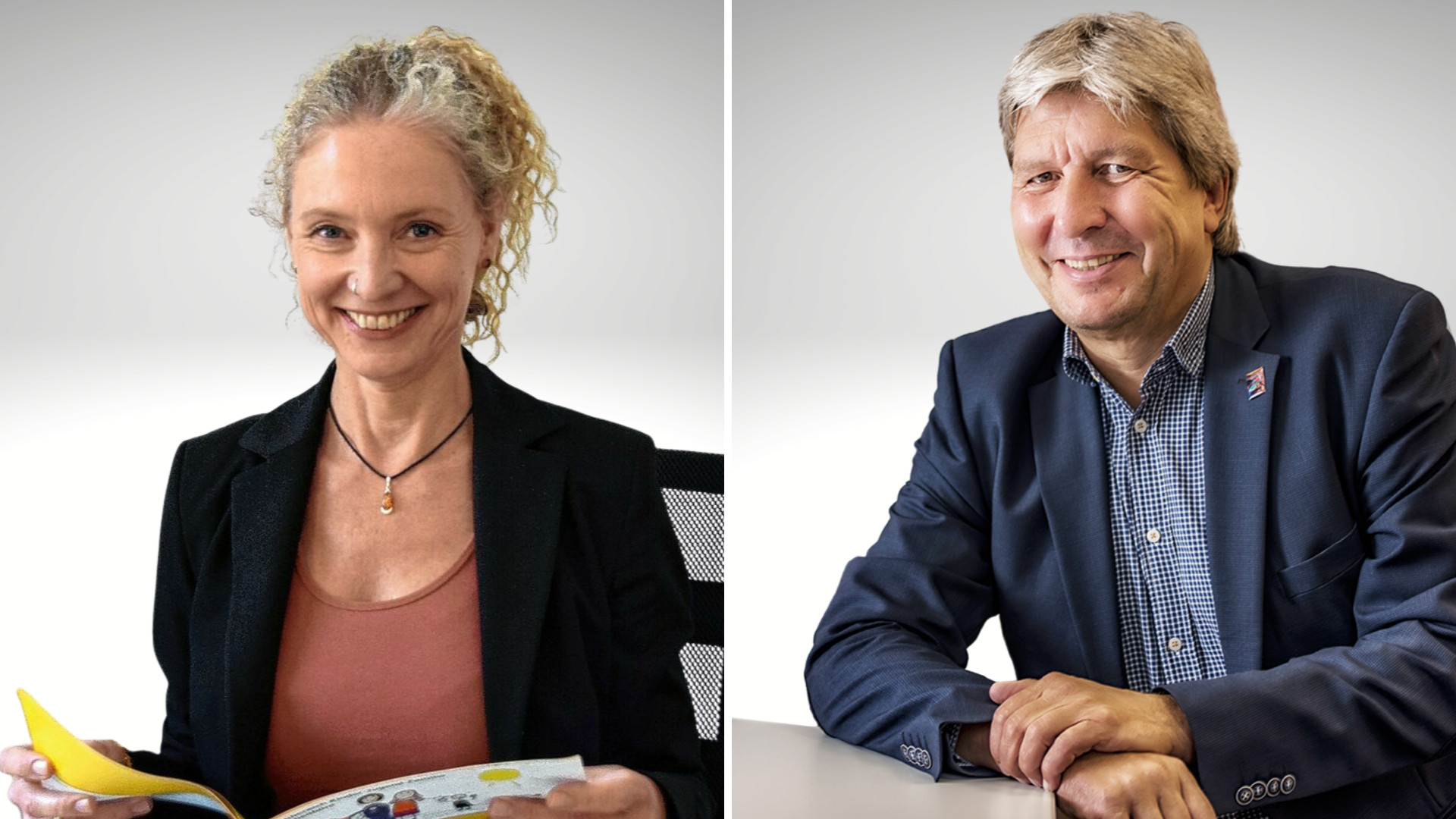 Zwei lächelnde Personen in Businesskleidung an einem Tisch.